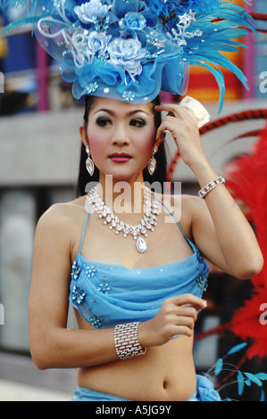 Femme au maillot bleu avec équipement de tête fantaisie tenant de l'argent pendant le spectacle Alcazar à Bangkok Thaïlande Asie du Sud-est Banque D'Images