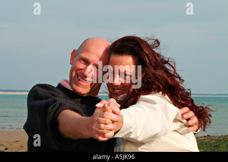 Les amoureux de MR marche à Seacoast dans une joyeuse embracement Banque D'Images