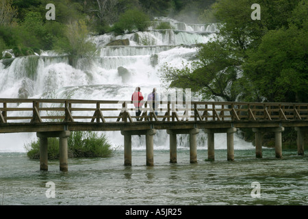 Chutes de Skradin avec touristes traversant la rivière du pont de bois à travers la Croatie Banque D'Images