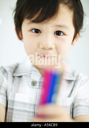 Young boy holding crayons de couleur Banque D'Images