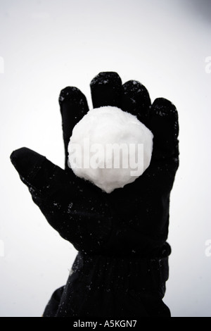 Une boule de neige qui a eu lieu dans un gant noir Banque D'Images