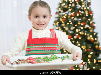 Girl carrying tray of Christmas Cookies Banque D'Images