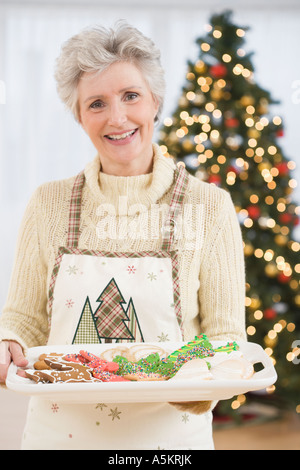 Senior woman holding tray of Christmas Cookies Banque D'Images