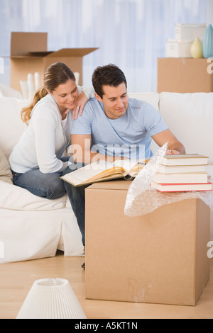 Couple unpacking books in new house Banque D'Images