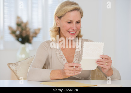 Senior woman reading card Banque D'Images