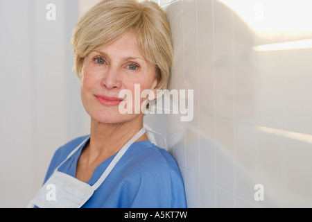Portrait of senior female doctor contre mur Banque D'Images