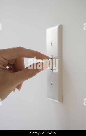 Portrait de femme tournant le contacteur d'éclairage Banque D'Images