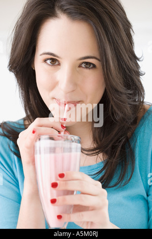 Woman drinking milk-shake avec de la paille Banque D'Images