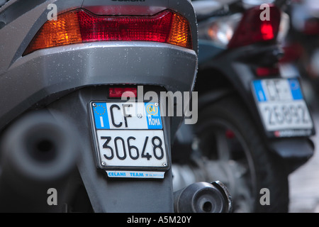 Nombre de plaques de cyclomoteurs garés dans une ligne sur une rue de Rome Italie Banque D'Images