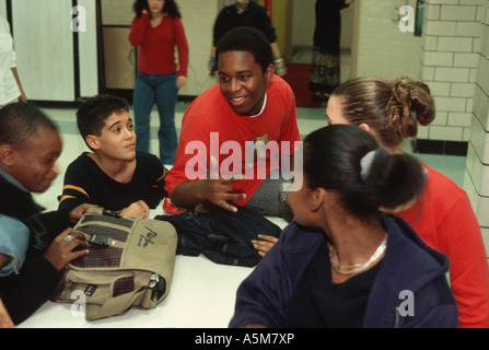 Jeunes élèves du secondaire en train de socialiser dans la salle du déjeuner d'une école publique de New York. Banque D'Images