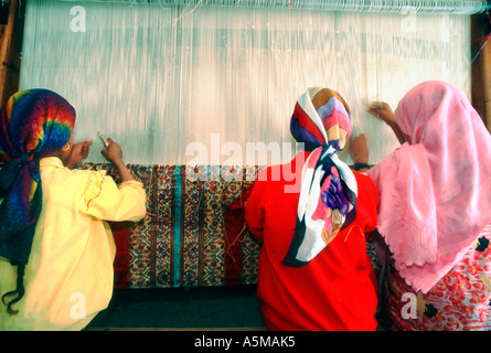 Saqqarah Égypte, petits groupes de personnes, jeunes filles musulmanes égyptiennes dans la tête écharpes tapis tissé DANS LE tapis usine Conditions de travail des enfants Banque D'Images