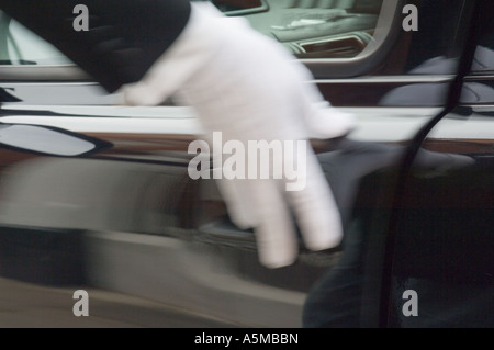 Le port de gant blanc à la main formelle d'ouverture de porte de voiture. Cinq étoiles de luxe. Service. Banque D'Images