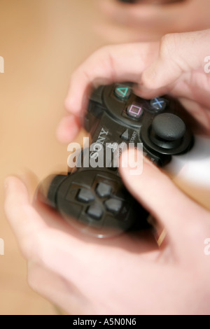 Les MAINS D'UNE PERSONNE JOUANT UN JOYPAD DE CONSOLE DE JEUX Banque D'Images
