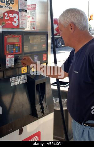 Mâle adulte en utilisant sa carte de crédit à une machine automatique de la pompe à carburant. Banque D'Images