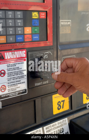 Mâle adulte en utilisant sa carte de crédit à une machine automatique de la pompe à carburant. Banque D'Images