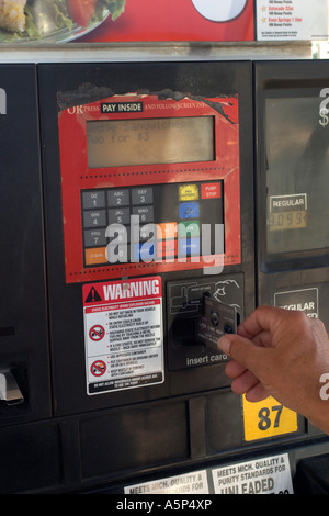 Mâle adulte en utilisant sa carte de crédit à une machine automatique de la pompe à carburant. Banque D'Images