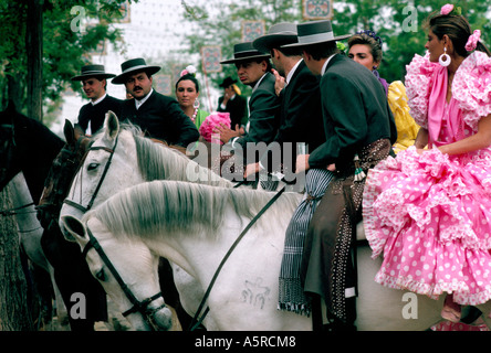 Des hommes en costume gris TRADITIONNEL DES FEMMES HABILLÉES DANS SAVILLANAS COSTUME FLAMENCO DEUX CIRCONSCRIPTION JUSQU'À CHEVAL JUSTE À SÉVILLE Banque D'Images