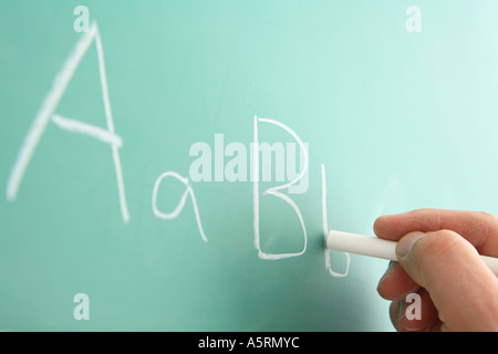 School teacher writing on chalkboard alphabet Banque D'Images