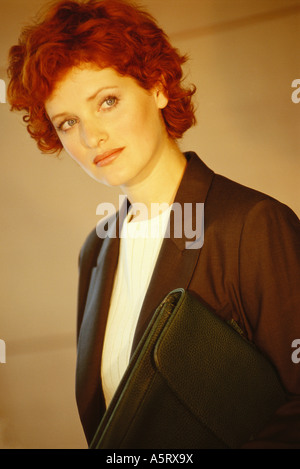 Businesswoman standing with briefcase underarm, portrait Banque D'Images