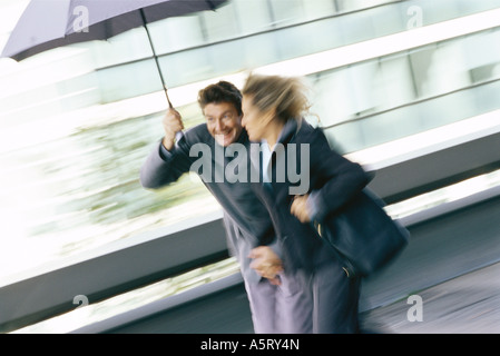 Mature couple walking under umbrella Banque D'Images