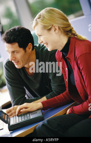 L'homme et de la femme à l'aide d'un ordinateur portable, smiling, Portrait Banque D'Images