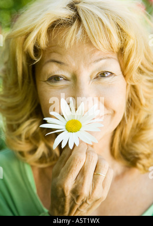 Senior woman with flower, portrait Banque D'Images