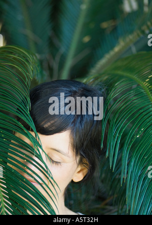 Femme debout entre les feuilles, la tête et épaules Banque D'Images