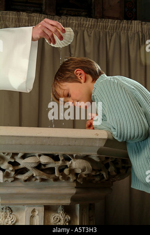 Le baptême chrétien sacrement, l'onction d'une tête de l'enfant avec l'eau bénite. Banque D'Images