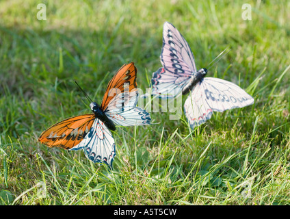 Faux les papillons dans l'herbe Banque D'Images