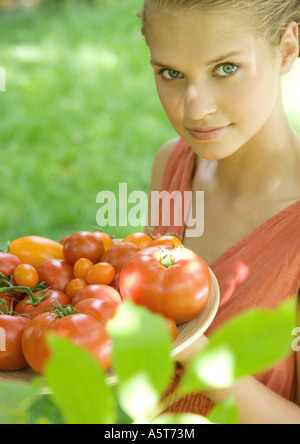 Woman holding bowl full of tomatoes Banque D'Images