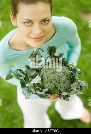 Young woman holding up broccoli Banque D'Images