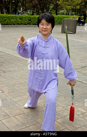 Arts Martiaux Chinois dame en bleu violet jump suit pratiquant avec une épée, Shanghai Banque D'Images