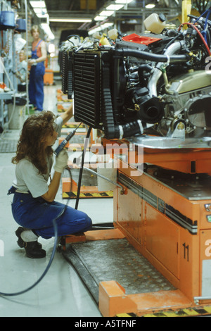 Femme travaillant à l'usine de Saab avec des moteurs sur des chariots automatisés en Suède Banque D'Images