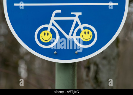 Autocollants Smiley sur un signe de voies cyclables Allemagne Banque D'Images