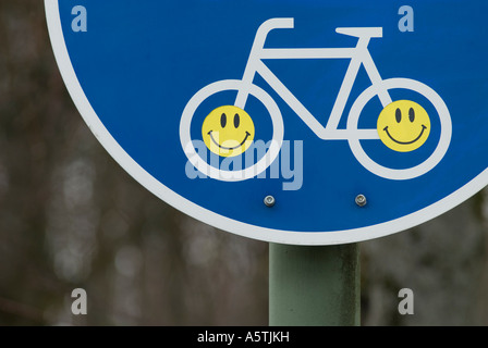 Autocollants Smiley sur un signe de voies cyclables Allemagne Banque D'Images