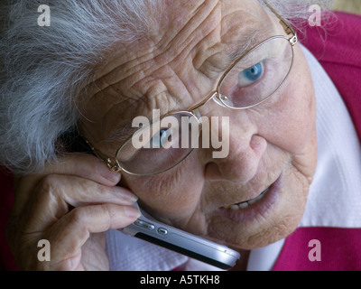 Vieille dame inquiète à la maison parle avec anxiété sur son téléphone Banque D'Images