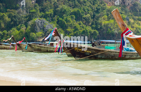 Bateaux Longtail sur Railay Beach à l'ouest de la mer d'Andaman en dessous de ce qu'on appelle l'Thaiwand Wall rock formation au sud de la Thaïlande Banque D'Images