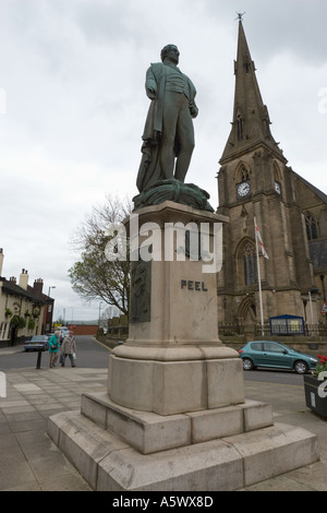 Sir Robert Peel Statue sur la place du marché, enterrez le centre-ville avec église en arrière-plan et ciel couvert dans le lancashire royaume-uni Banque D'Images