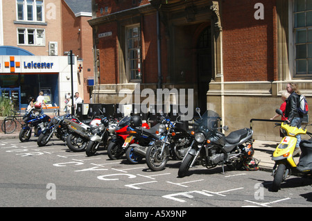 Moto garée dans un stationnement désigné sur une rue de la ville. Banque D'Images