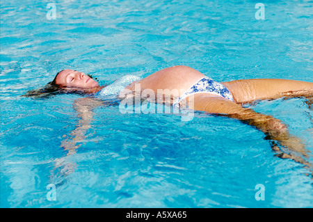 États-unis Hawaii Kauai pregnant woman floating on retour dans la piscine Banque D'Images