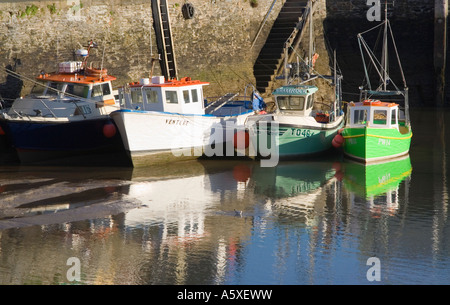 Quatre bateaux de pêche reflète dans l'eau. Marée basse. Padstow Harbour. Cornouailles du nord. UK. Banque D'Images
