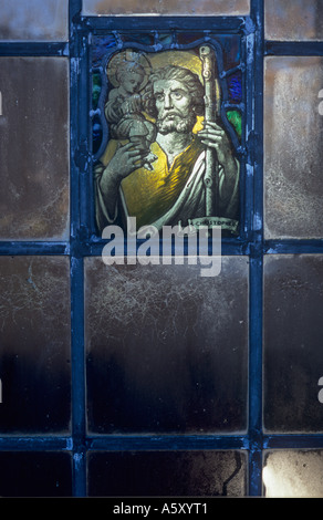 Petite rétro atmosphérique de vitraux représentant St Christophe avec son personnel et de l'enfant Jésus Christ sur son épaule Banque D'Images