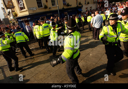 Les agents de police au cours de la difficulté à attirer des bâtons entre football soccer fans boire de l'alcool dans la région de Mill Lane Cardiff South Wales UK Banque D'Images