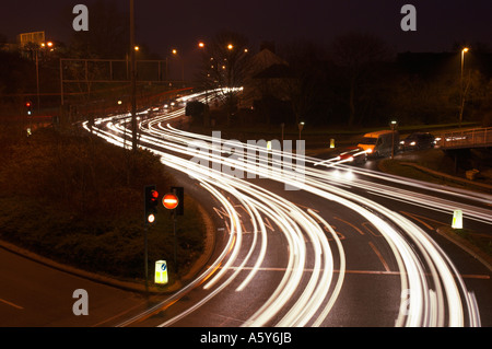 Des sentiers de lumière causé par le trafic d'une route très fréquentée à l'intersection avec feux de circulation England UK Banque D'Images