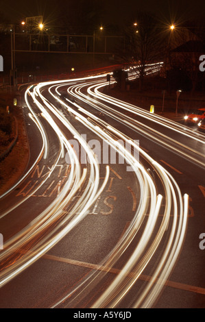 Des sentiers de lumière causé par le trafic d'une route très fréquentée à l'intersection avec feux de circulation England UK Banque D'Images