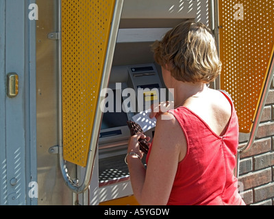 Obtenir de l'argent à partir de la femme d'un guichet automatique de billets ATM bancomat Banque D'Images