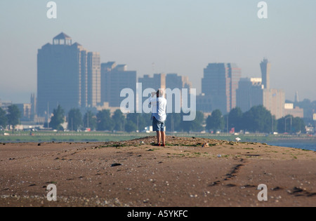 Man Standing on sand dune binoculars New Haven Connecticut Shoreline Banque D'Images