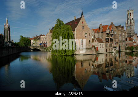 Bruges en Belgique. Vue sur le canal avec le Beffroi sur la droite et l'église Notre Dame sur la gauche. Banque D'Images