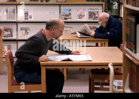 Les hommes de lire les journaux dans une bibliothèque salle des périodiques Banque D'Images