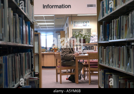 Un homme lisant le journal dans une bibliothèque Banque D'Images
